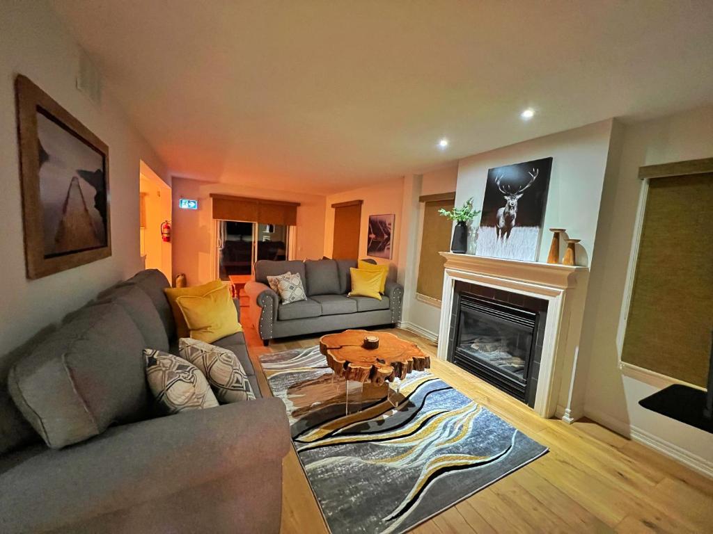 uma sala de estar com um sofá e uma lareira em Luxurious Blue Mountain 3BR & 3BTH Walk-in to Village em Blue Mountains