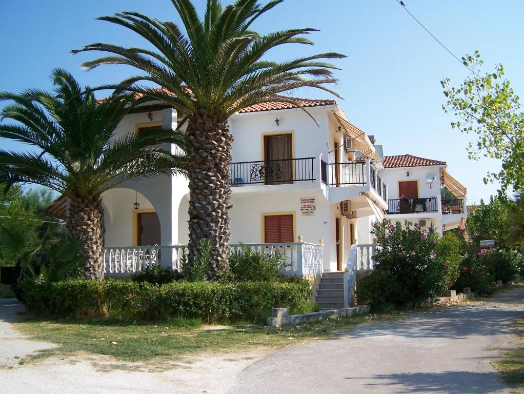 a house with two palm trees in front of it at renesis studios in Lithakia