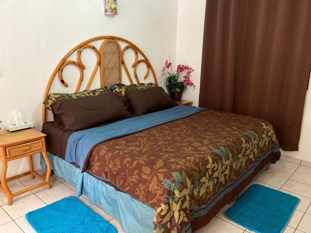 1 dormitorio con 1 cama grande con alfombras azules en Hostal Casa Blanca, en Comala