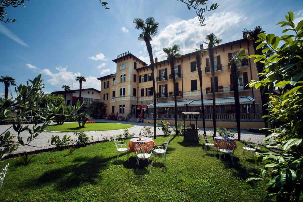 cortile con tavolo e sedie di fronte a un edificio di Hotel Maderno a Toscolano Maderno