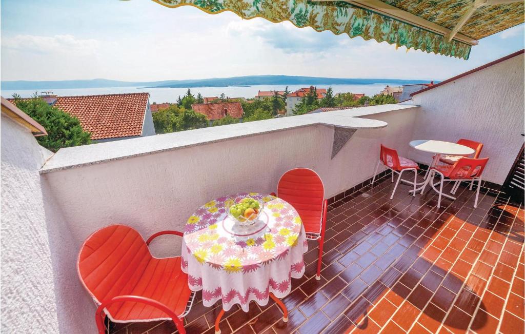 a patio with a table and chairs on a balcony at Nice Apartment In Crikvenica With House Sea View in Crikvenica