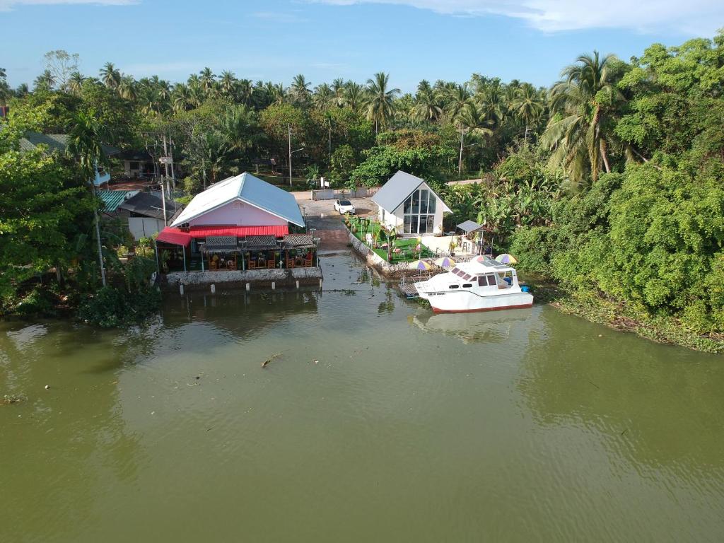 un barco está atracado junto a una casa en un río en Boat house marina restaraunt and homestay en Surat Thani