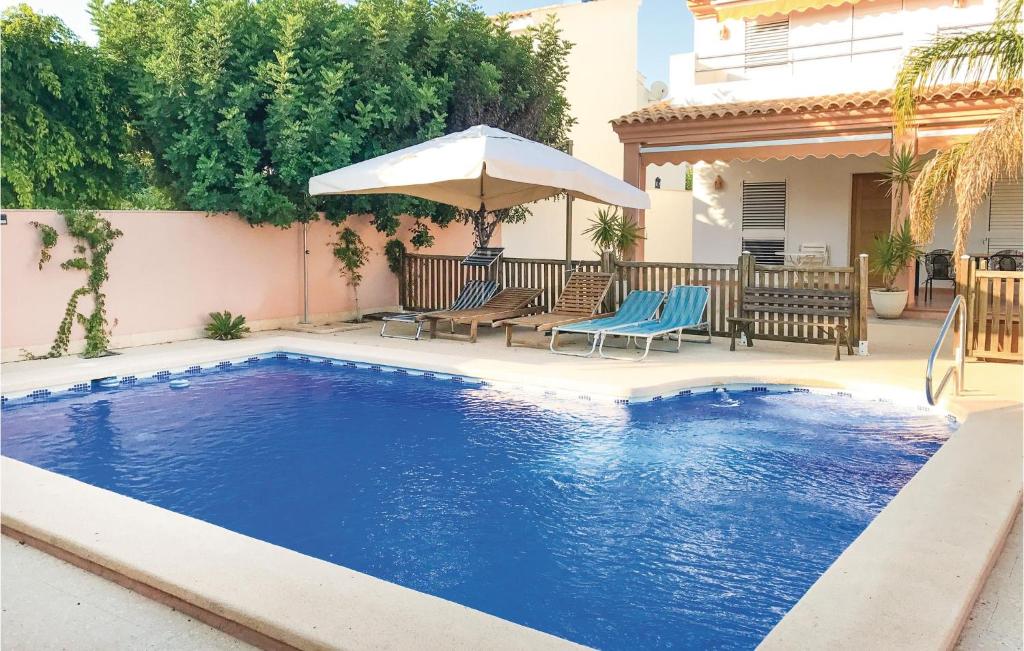 a swimming pool with an umbrella and chairs and a house at 6 Bedroom Beautiful Home In La Azohia in La Azohía