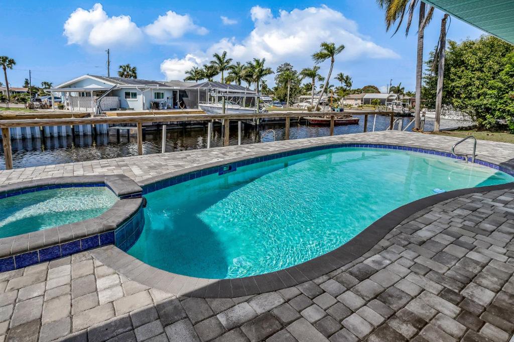 a swimming pool with a brick walkway around it at Hip Harbour in North Fort Myers