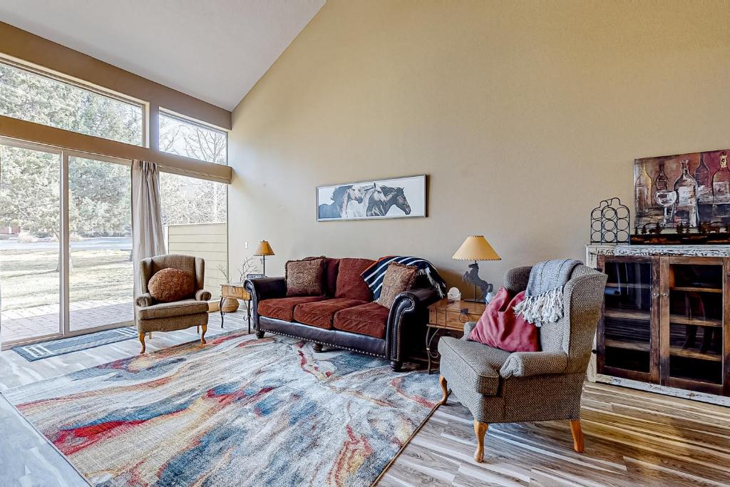 un soggiorno con un divano rosso e 2 sedie di Eagle Crest Highland Getaway a Redmond