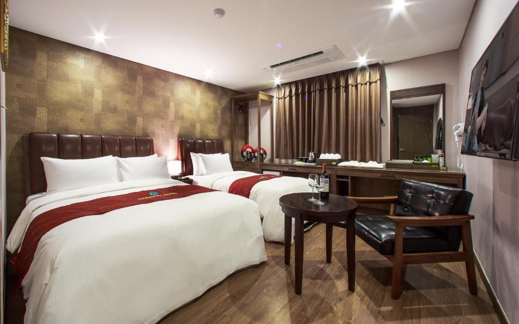 首爾的住宿－華美倫酒店，酒店客房配有两张床和一张书桌