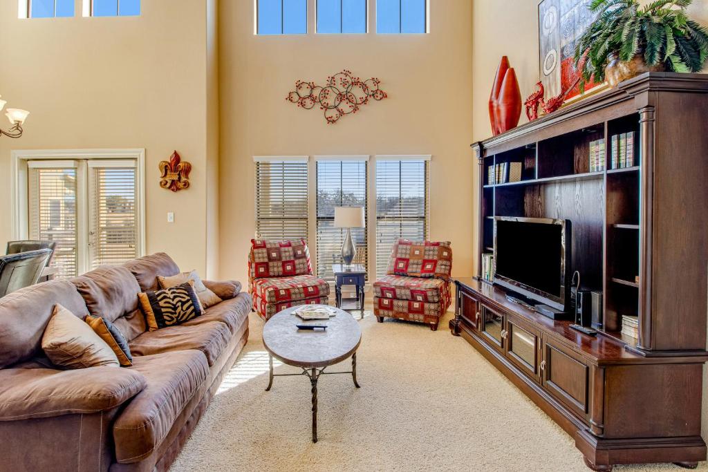 a living room with a couch and a tv at Golfer's Paradise in New Braunfels