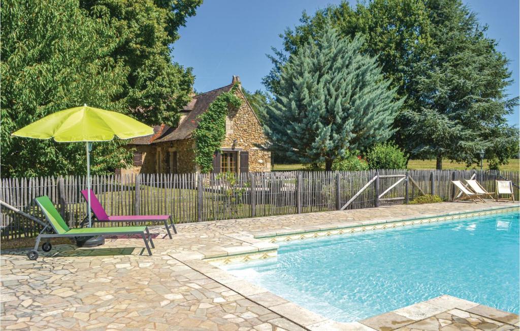 a swimming pool with a chair and an umbrella next to a house at Stunning Home In Campsegret With 4 Bedrooms, Private Swimming Pool And Outdoor Swimming Pool in Campsegret