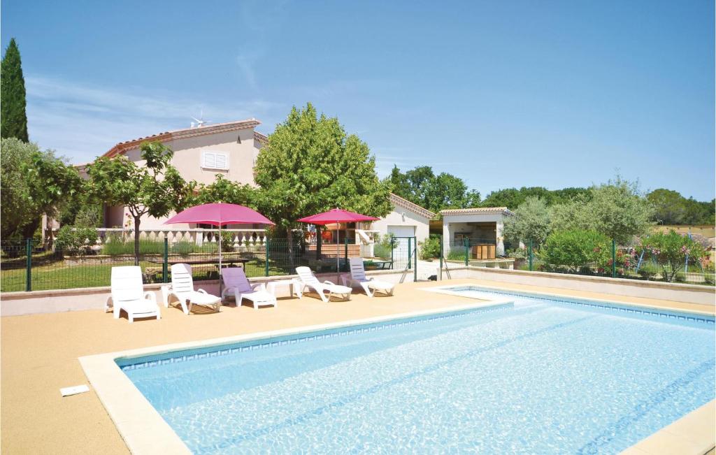 a swimming pool with lounge chairs and a house at Nice Home In Montignargues With 4 Bedrooms, Wifi And Private Swimming Pool in Montignargues
