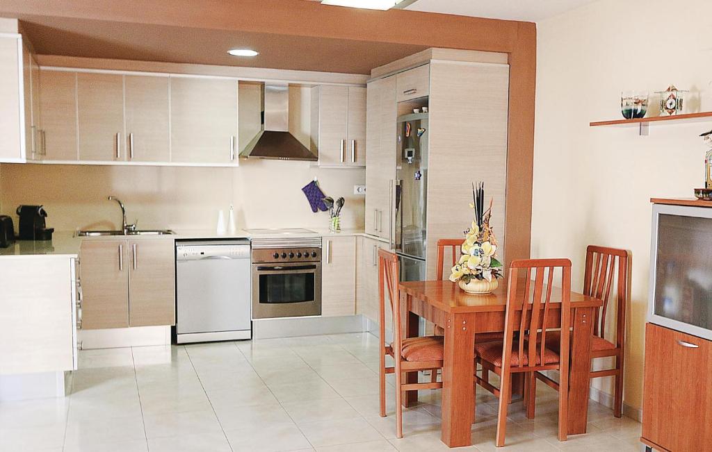 a kitchen with a wooden table and a kitchen with white appliances at Amazing Apartment In Pineda De Mar With Kitchen in Pineda de Mar