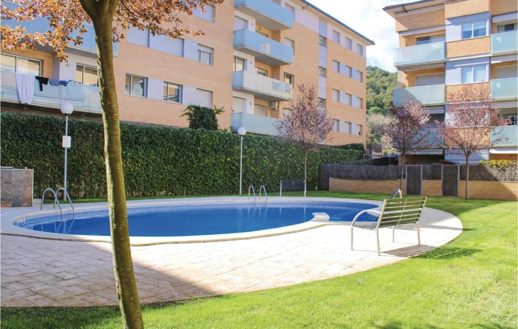 a swimming pool with a chair next to a building at Stunning Apartment In Tossa De Mar With 2 Bedrooms, Wifi And Outdoor Swimming Pool in Tossa de Mar
