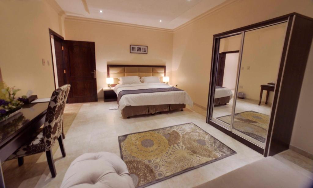 1 dormitorio con cama y espejo en City Suites, en Al Khobar