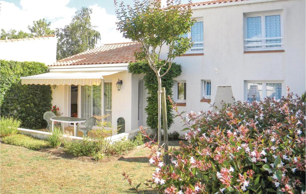a white house with a garden in front of it at Beautiful Home In La Faute Sur Mer in La Faute-sur-Mer