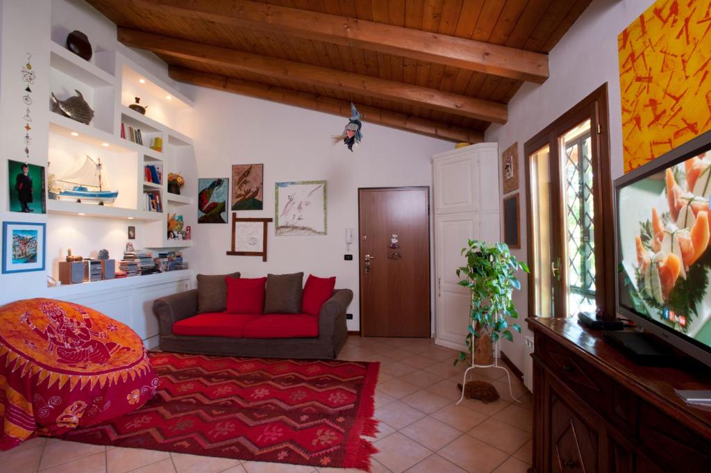 sala de estar con sofá rojo y TV en Elena Paternoster, en San Lazzaro di Savena