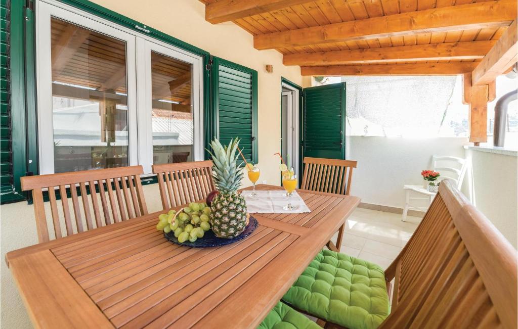 einen Holztisch mit Ananas und Getränke auf der Veranda in der Unterkunft Awesome Home In Pag With 3 Bedrooms And Wifi in Pag