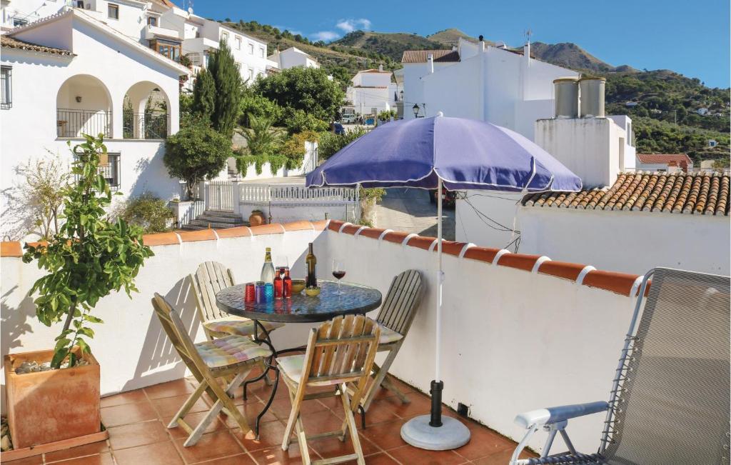 een patio met een tafel en stoelen en een parasol bij Nice Home In Canillas De Albaida With Wifi in Canillas de Albaida