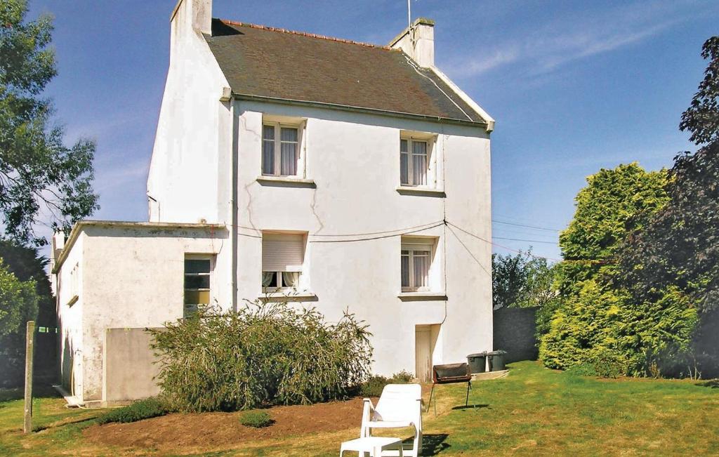 une maison blanche avec deux chaises devant elle dans l'établissement 3 Bedroom Lovely Home In Landudec, à Landudec