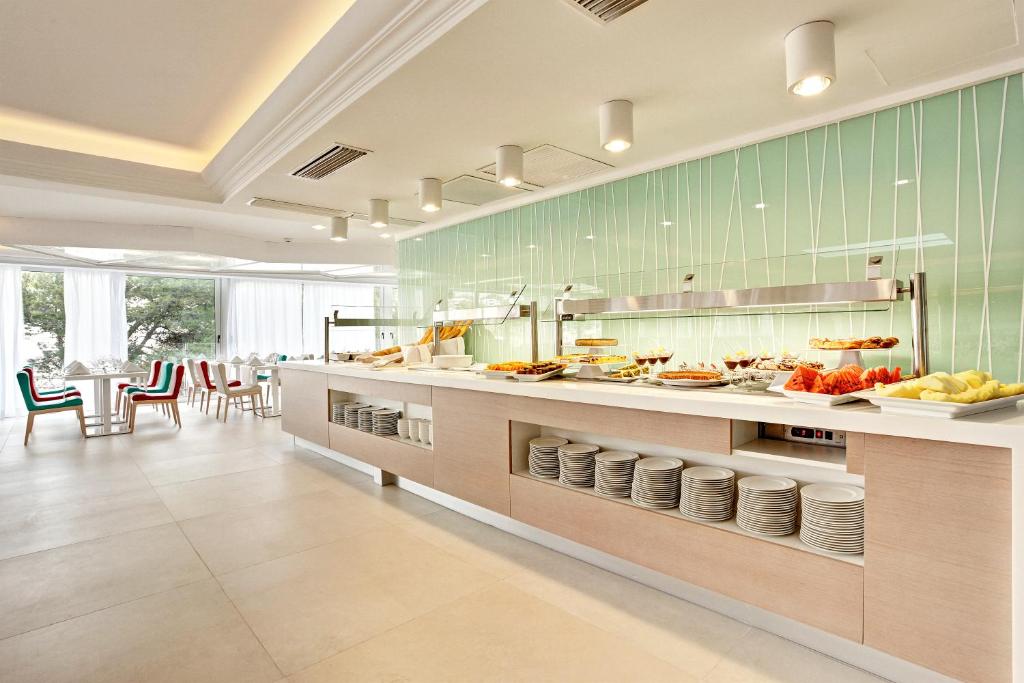 a large kitchen with a counter with food on it at Grupotel Ibiza Beach Resort - Adults Only in Portinatx