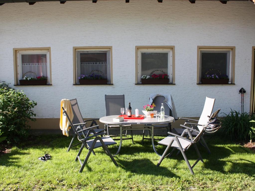 uma mesa e cadeiras na relva em frente a uma casa em Spacious holiday home in Neureichenau Schimmelbach em Neureichenau