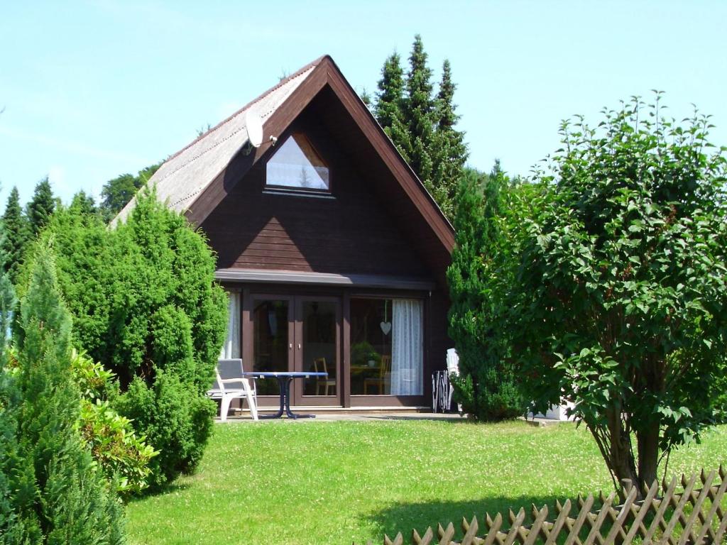 a small house with a table in a yard at Classy Holiday Home in Wolfshagen with Fenced Garden in Hahnenklee-Bockswiese