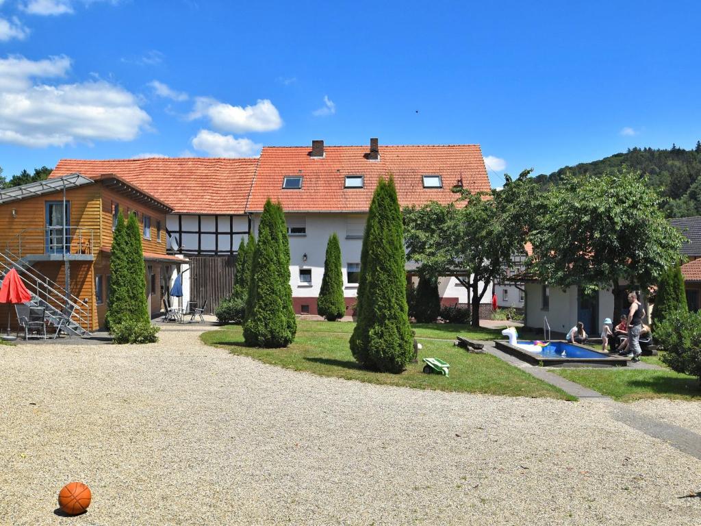 a house with a yard with a pool and trees at Apartment with private terrace in H ddingen in Bad Wildungen