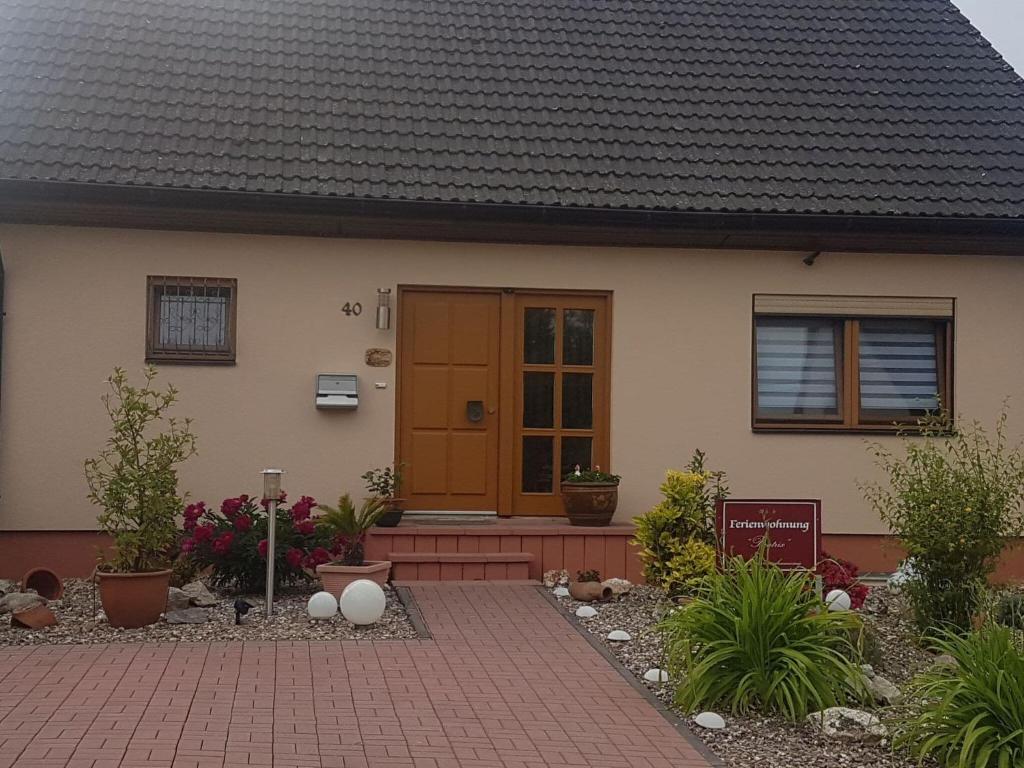 ein Haus mit brauner Tür und einigen Pflanzen in der Unterkunft Holiday home with garden in Neumagen Dhron in Neumagen-Dhron
