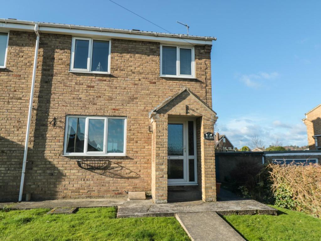 a brick house with a door and windows at Number Six in Burniston