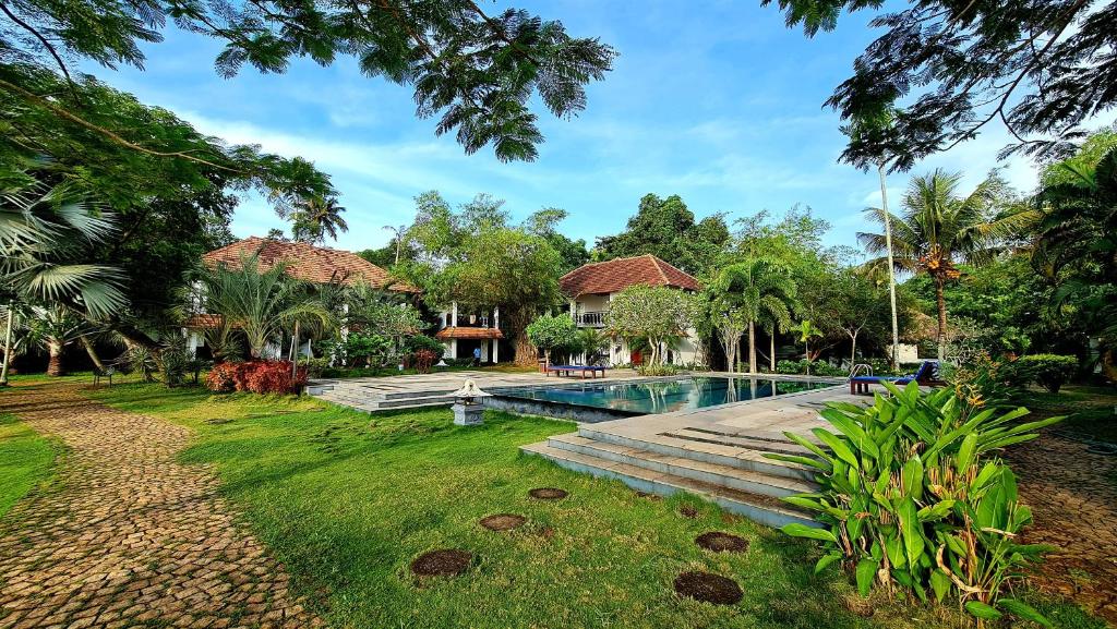 a house with a swimming pool in a yard at Deshadan Backwater Resort - The best sunrise view in Alleppey