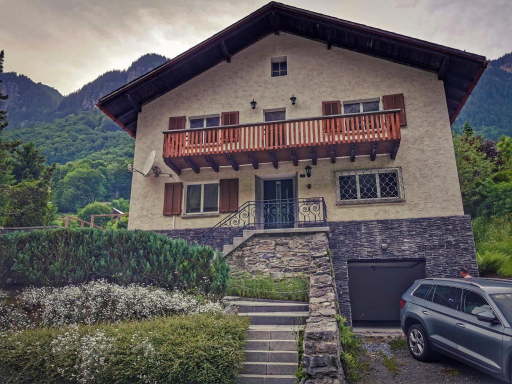 a house with a balcony and a car parked in front at Schwendi Maison in Mels