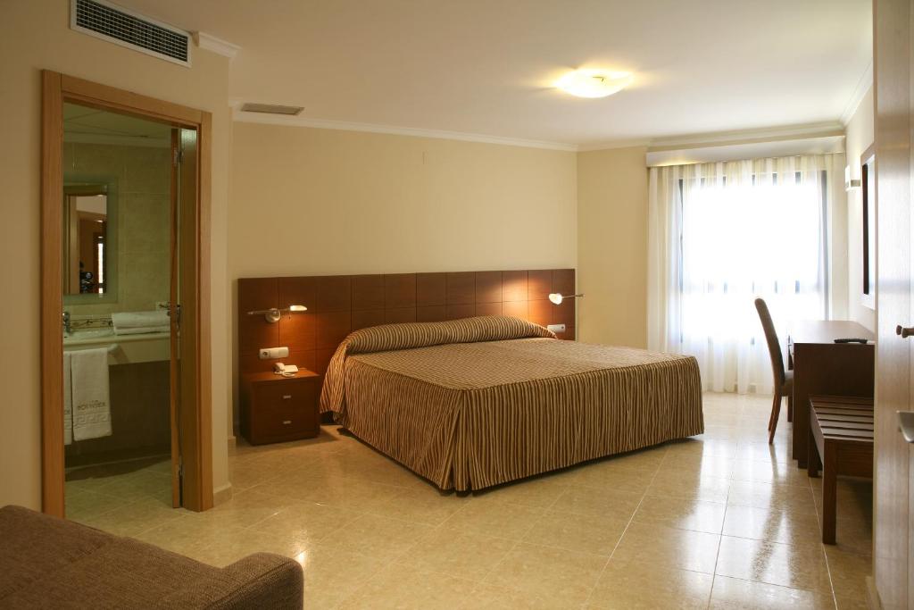 a bedroom with a large bed and a bathroom at Nou Avenida in Gata de Gorgos