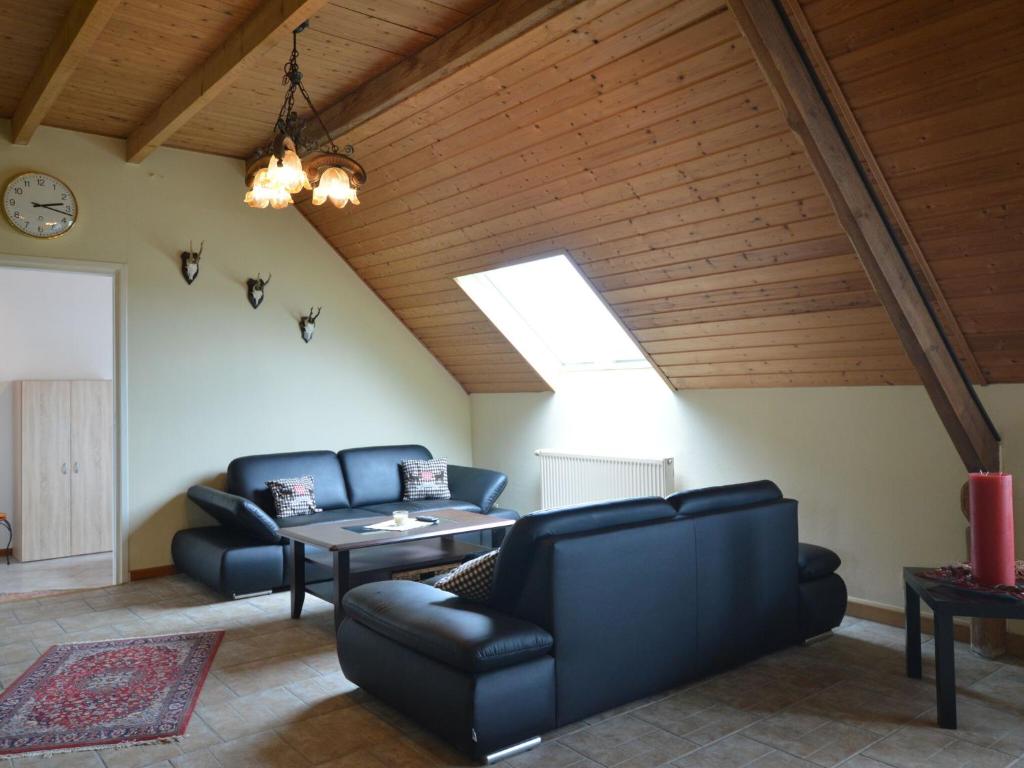 una sala de estar con muebles de cuero y tragaluz. en Roofed Farmhouse in Juchen with private terrace and garden, en Jüchen