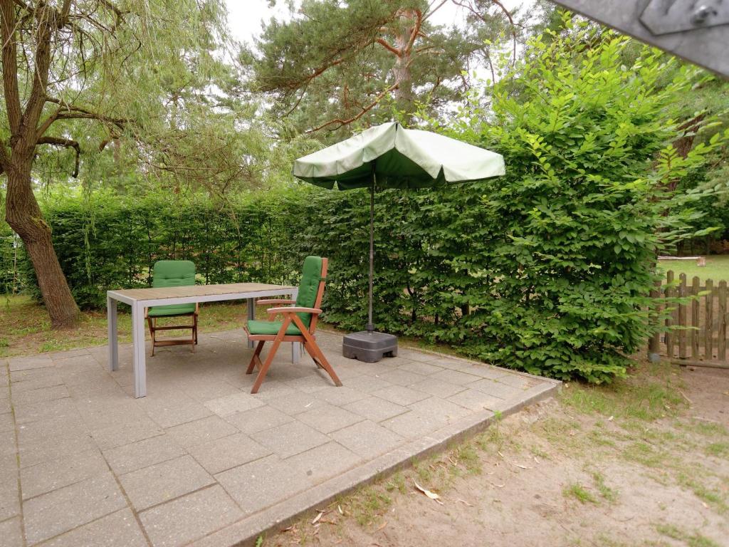 a table with two chairs and an umbrella at Elite holiday home with garden in Spreenhage in Grünheide