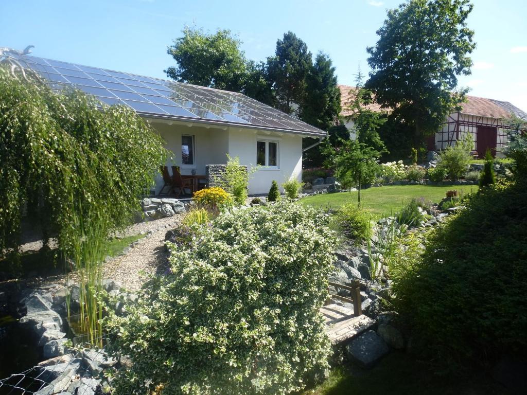 ein Haus mit Sonnenkollektoren auf dem Dach in der Unterkunft Cozy Holiday Home in Willersdorf with Pond in Frankenberg