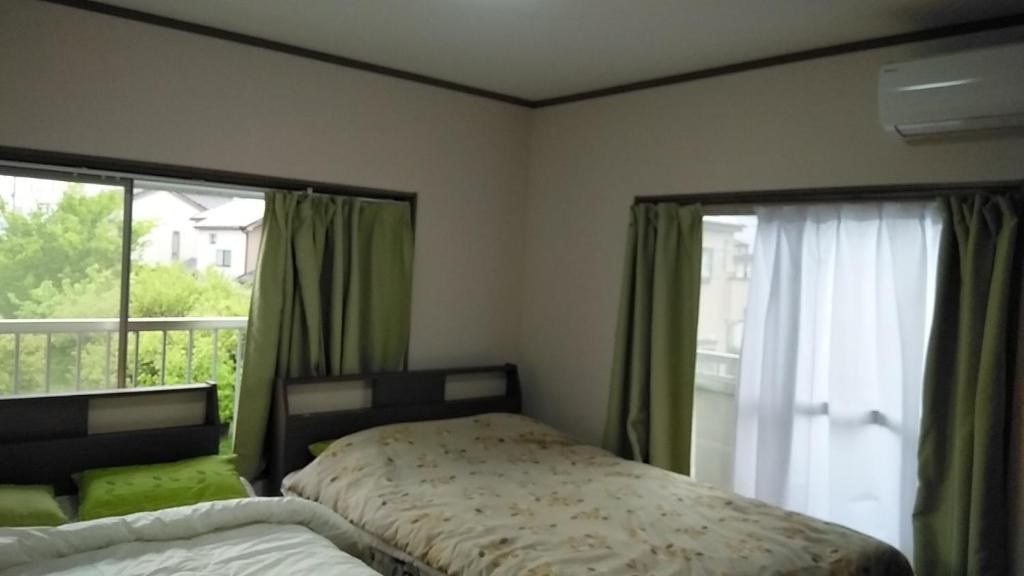 1 dormitorio con cama y ventana grande en コウノトリの里の宿 en Fukiage