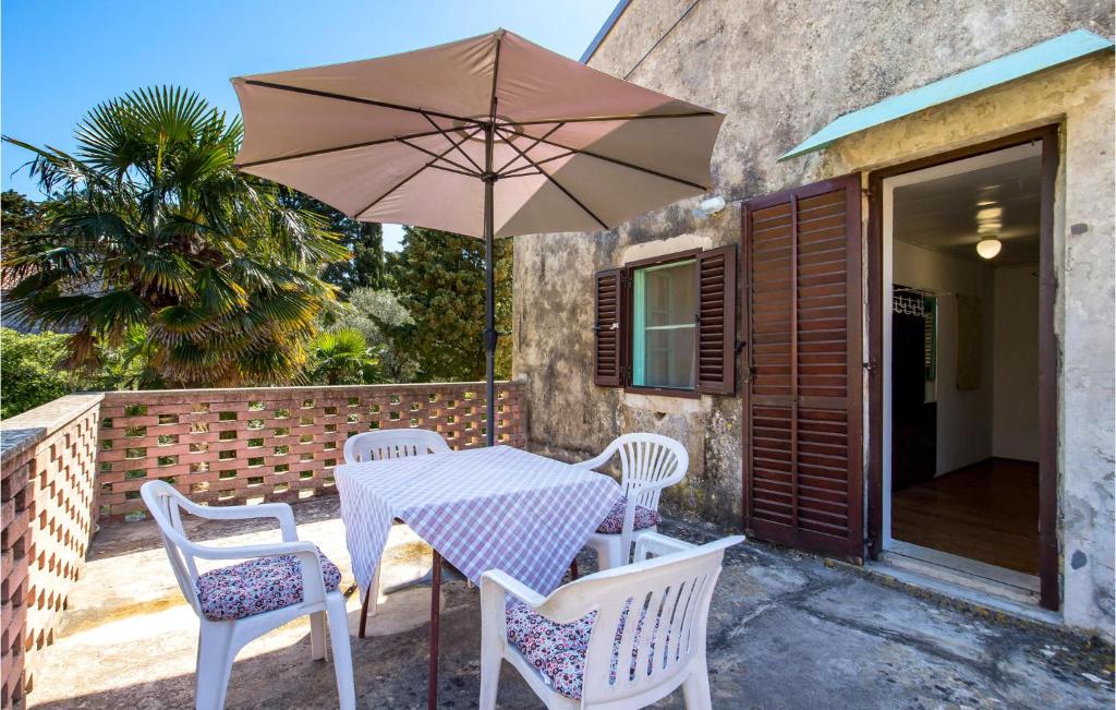 un tavolo e sedie con ombrellone su un patio di 3 Bedroom Lovely Home In Nerezine a Nerezine (Neresine)