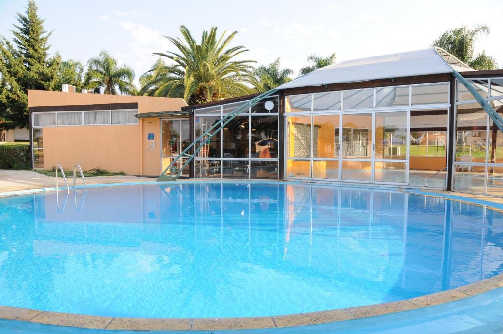 a large blue swimming pool in front of a building at Arapey Oasis Termal Hotel in Termas del Arapey
