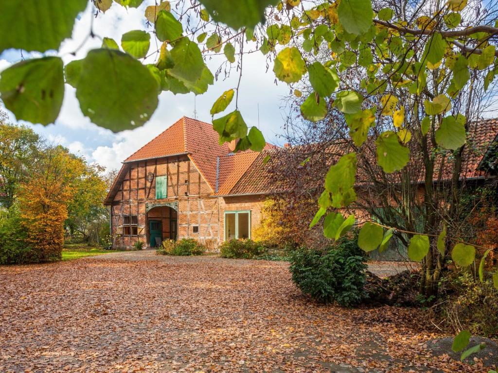 a stone house with a driveway in front of it at Historic half timbered Farm in Hohnebostel near Watersports in Langlingen