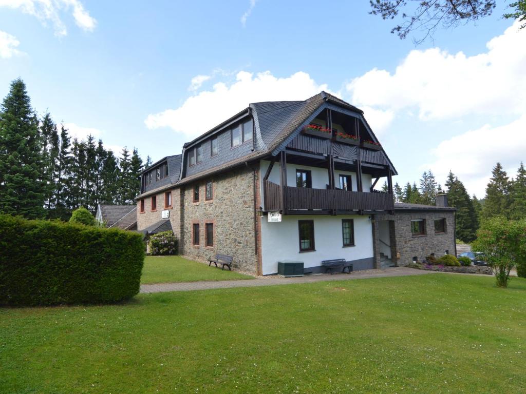 ein großes Backsteingebäude mit einem Gameradach in der Unterkunft Luxurious Holiday Home in Kalterherberg with Sauna in Alzen