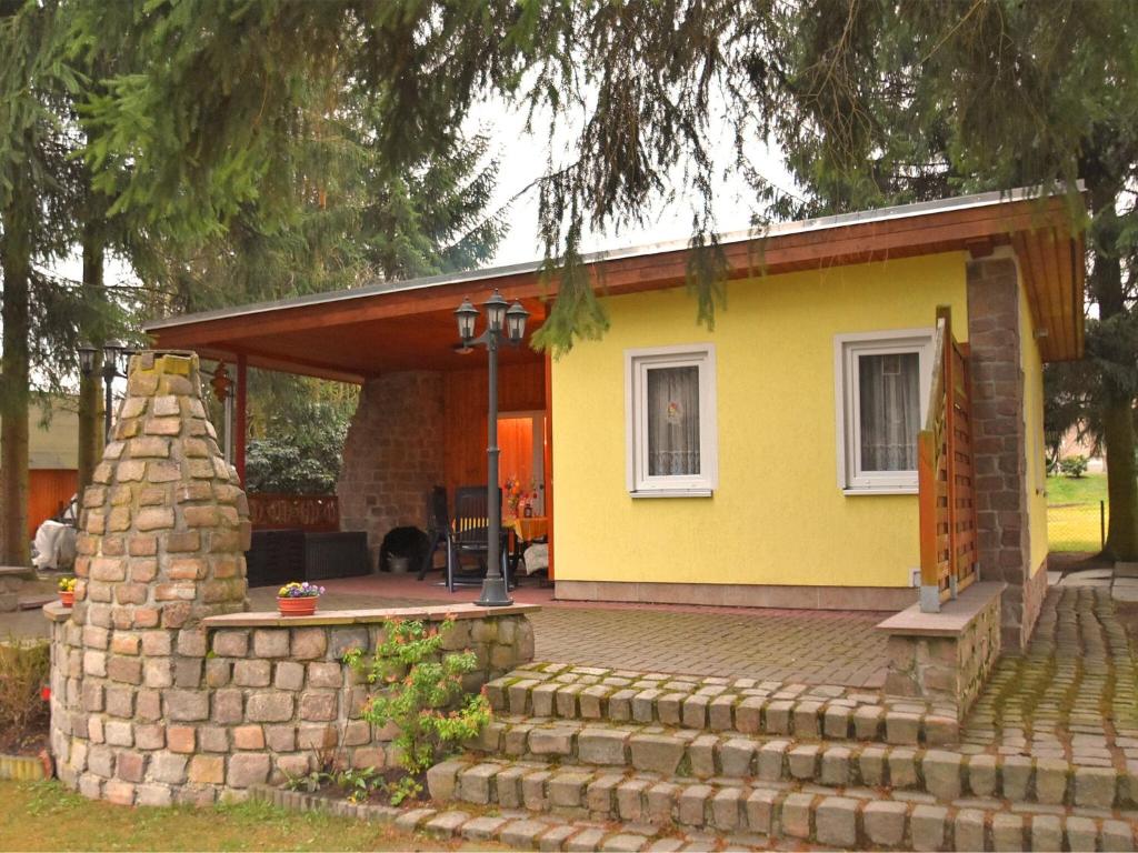 ein gelbes Haus mit Ziegelwand in der Unterkunft Vintage Holiday Home in Trieb with Terrace in Trieb