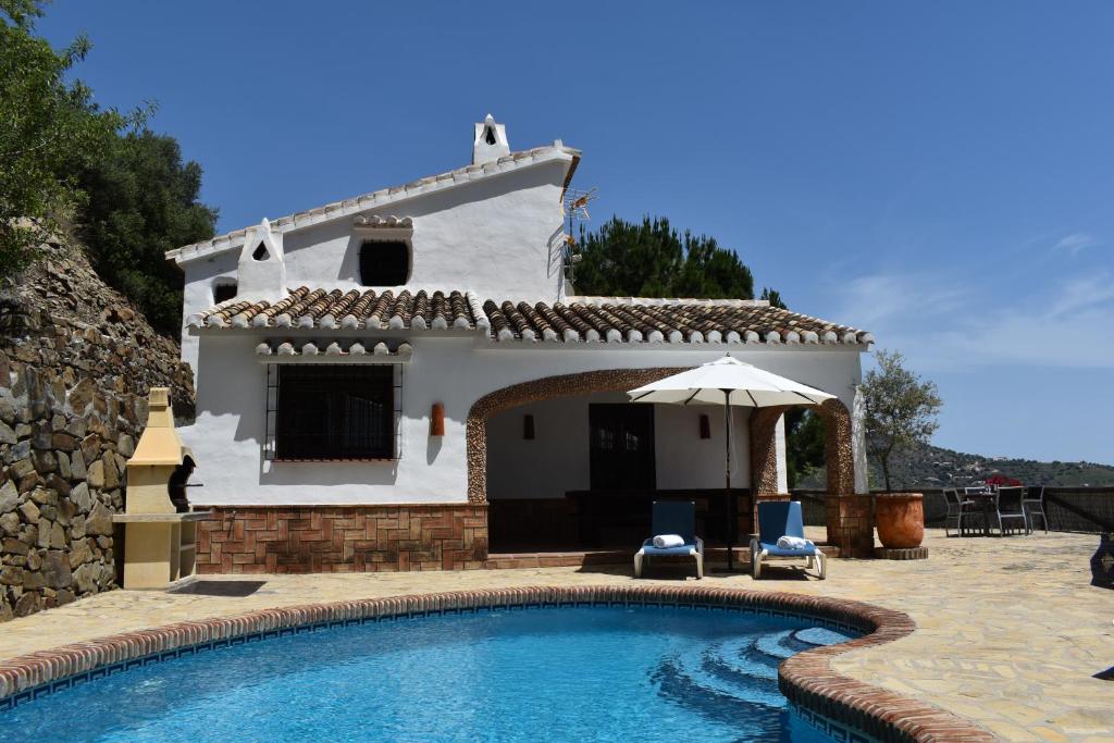 Villa con piscina frente a una casa en Finca Ventorrillo Competa en Cómpeta
