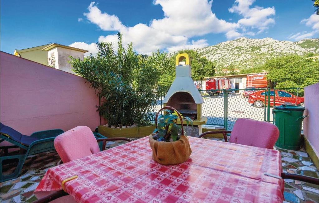 ein Tisch mit rosa Stühlen und ein Tisch mit einem Korb darauf in der Unterkunft 1 Bedroom Amazing Apartment In Karlobag in Karlobag