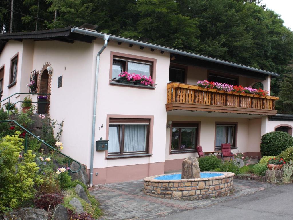 a house with a balcony and a fountain at Mountain view Apartment in Mullenborn Garden Terrace City Centre in Gerolstein