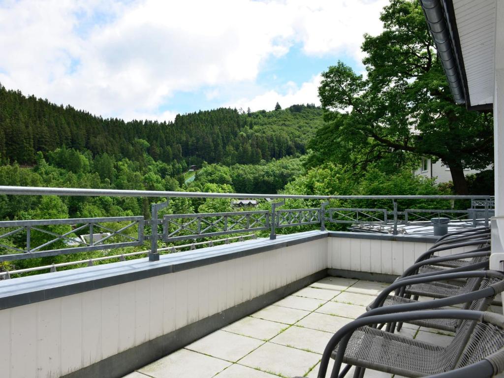 ヴィリンゲンにあるLarge Apartment in Willingen with Balconyの木々の景色を望むバルコニー(椅子付)