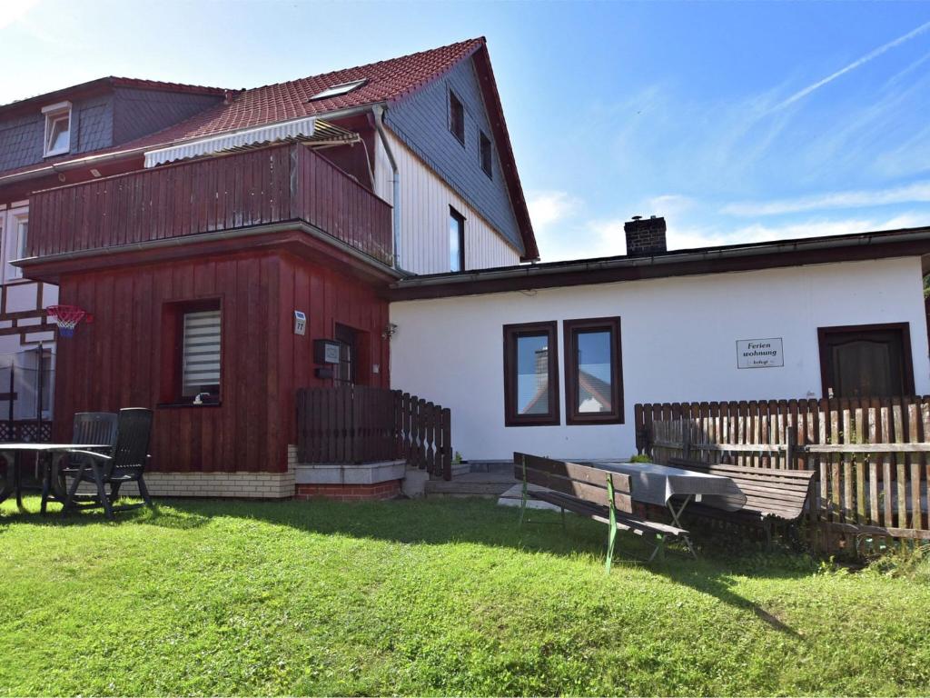 ein rotes und weißes Haus mit einem Tisch und einer Bank in der Unterkunft Classic holiday home in the Harz Mountains in Ilsenburg