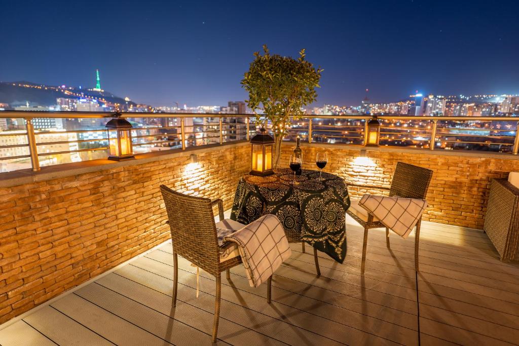 einen Tisch und Stühle auf einem Balkon mit Aussicht in der Unterkunft Reed Hotel Tbilisi in Tbilisi City