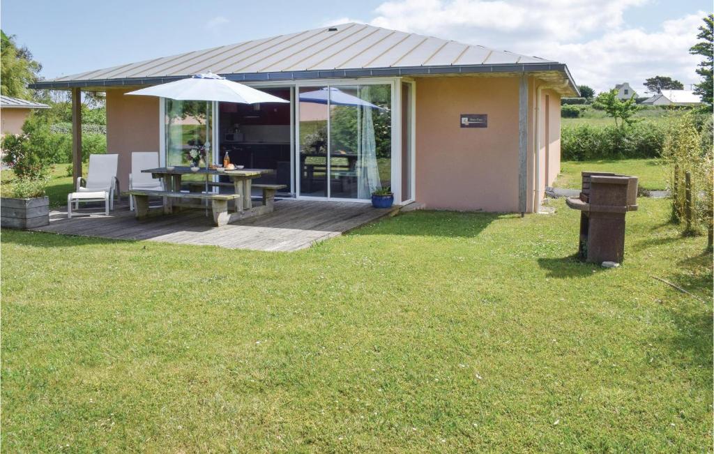 a house with a deck with a table and an umbrella at Beautiful Home In Guisseny With Kitchen in Guissény