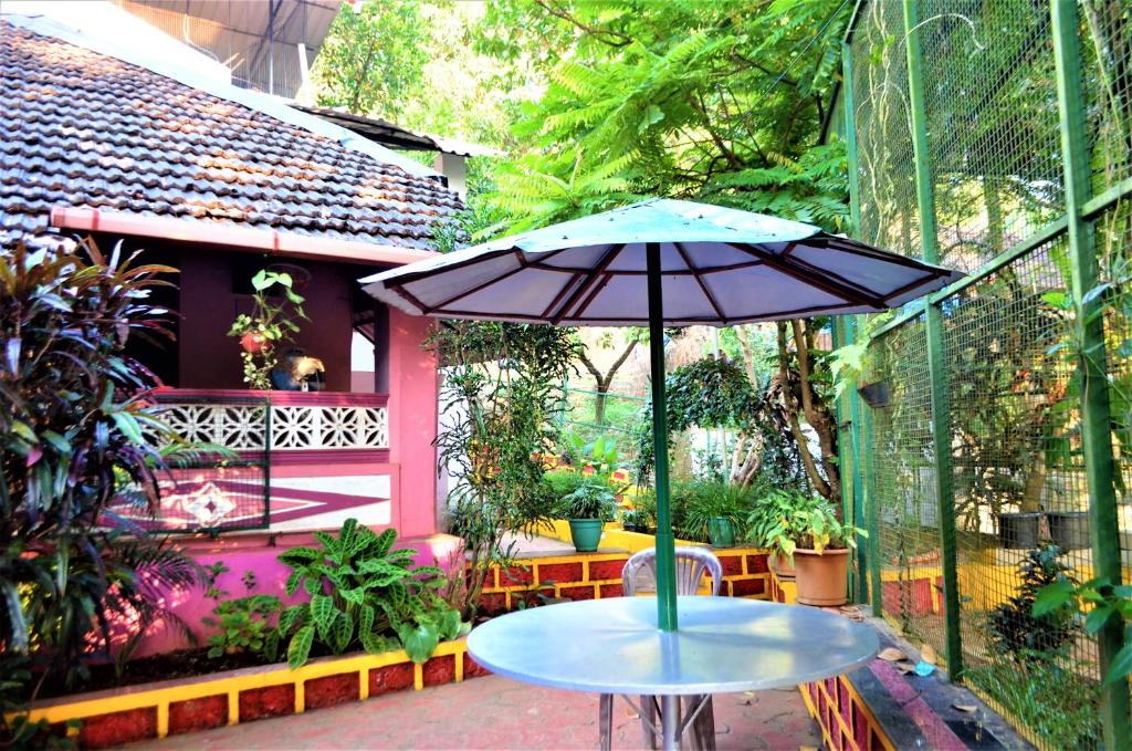 stół z parasolem na patio w obiekcie Marias house w mieście Siroda