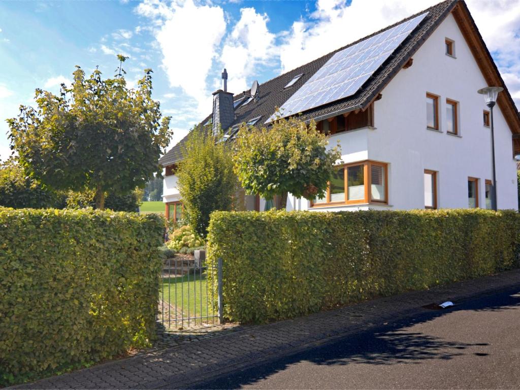 uma casa branca com um telhado solar e uma cerca em Apartment in Eslohe with terrace em Eslohe