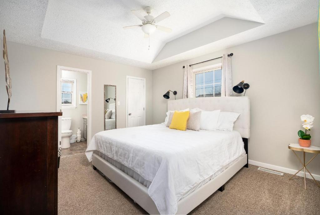 a white bedroom with a bed and a bathroom at 101 Karen Ct Conveniently Near Everything in Oak Grove