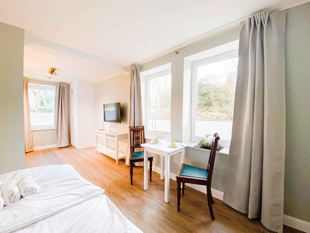 a bedroom with a bed and a table and a window at Ferienapartment Alte Bücherei in Mittelangeln
